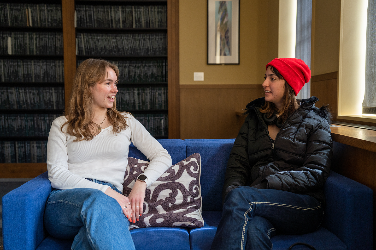 honors students in library sitting in chairs and talking to one another